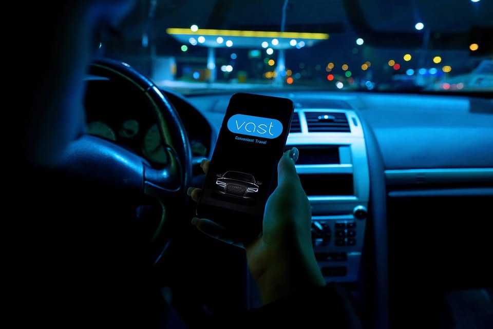 Smartphone showing charging status next to an electric vehicle charging station